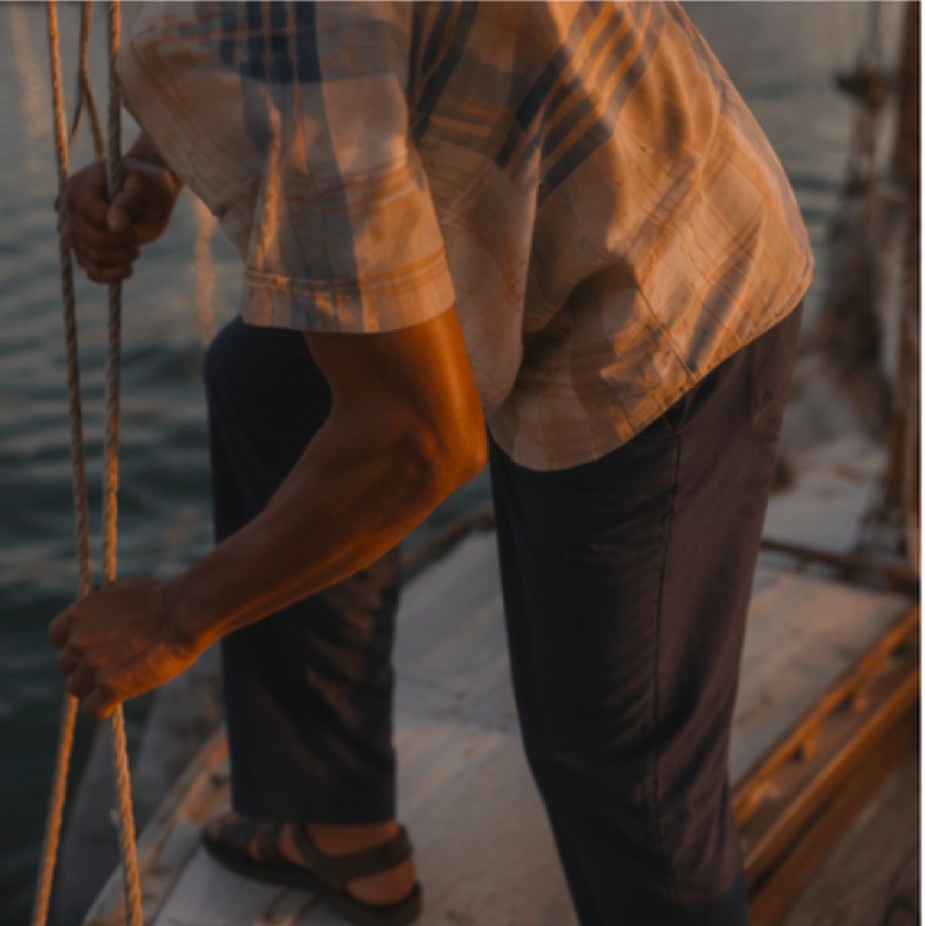 Close-up editorial image of clothing and sailboat rigging